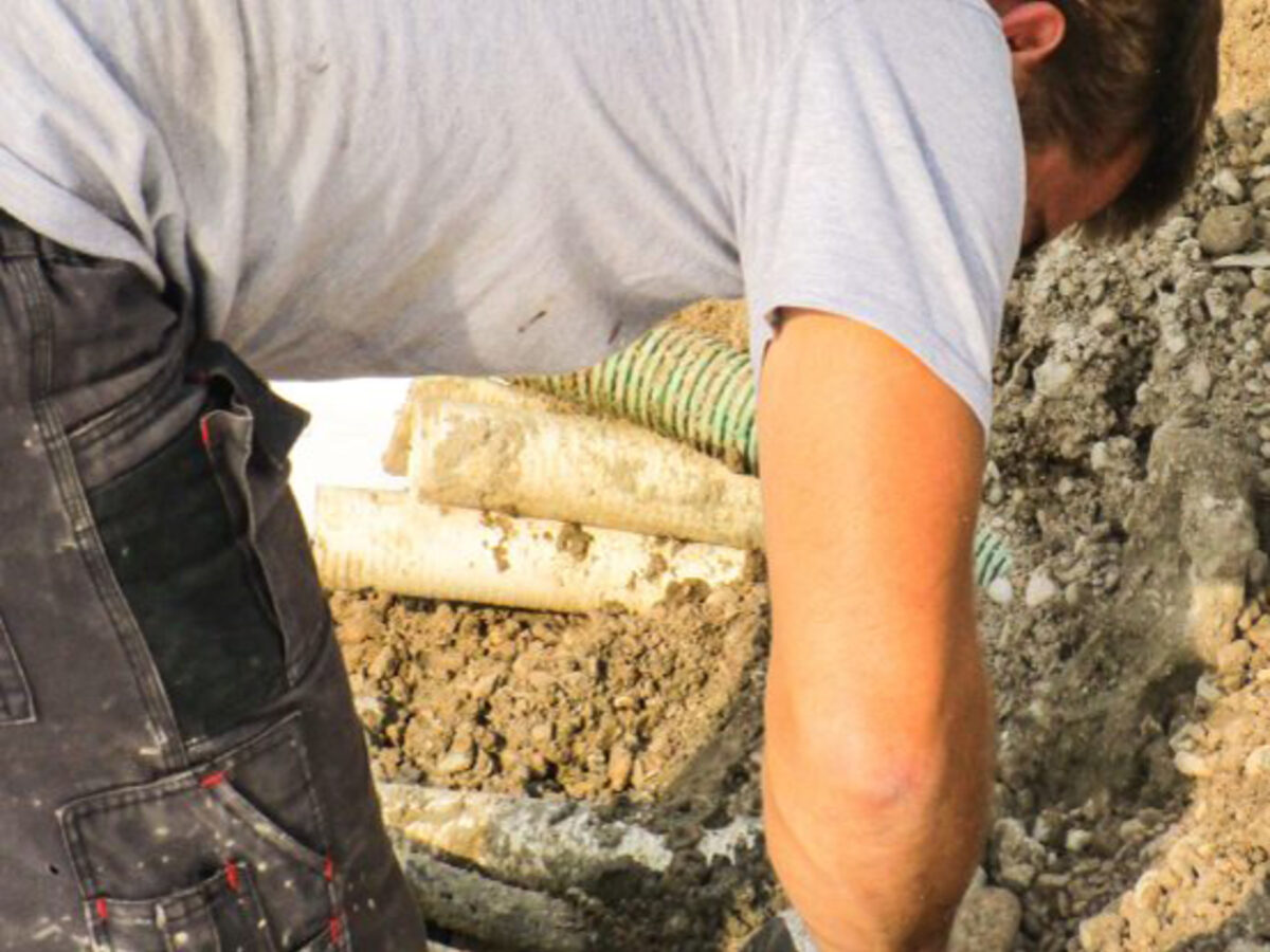 Technician fitting pipework and fittings before the structural layers