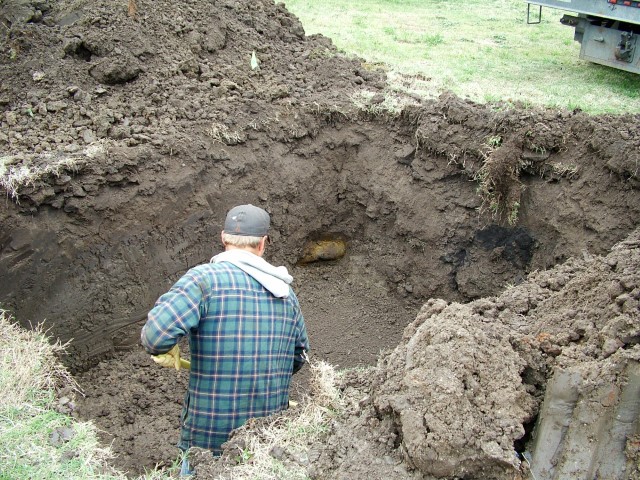 Worker excavating backyard.