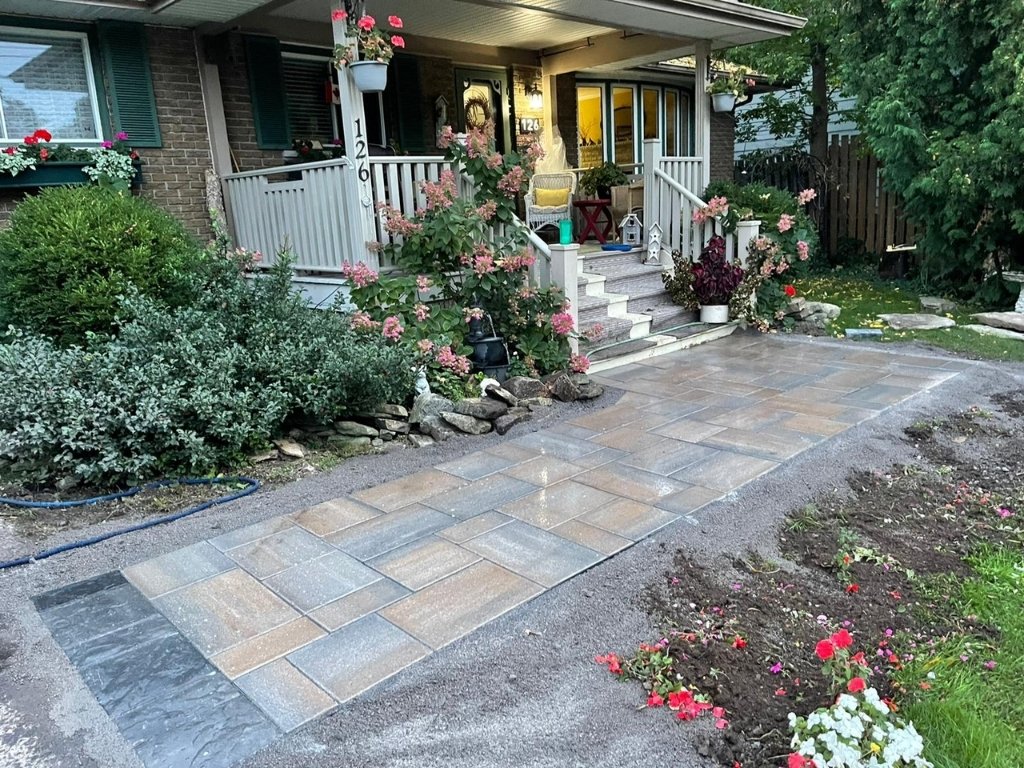 A picturesque home entrance featuring a newly installed interlocking paver pathway, enhancing the curb appeal and welcoming ambiance of the residence in Kanata.