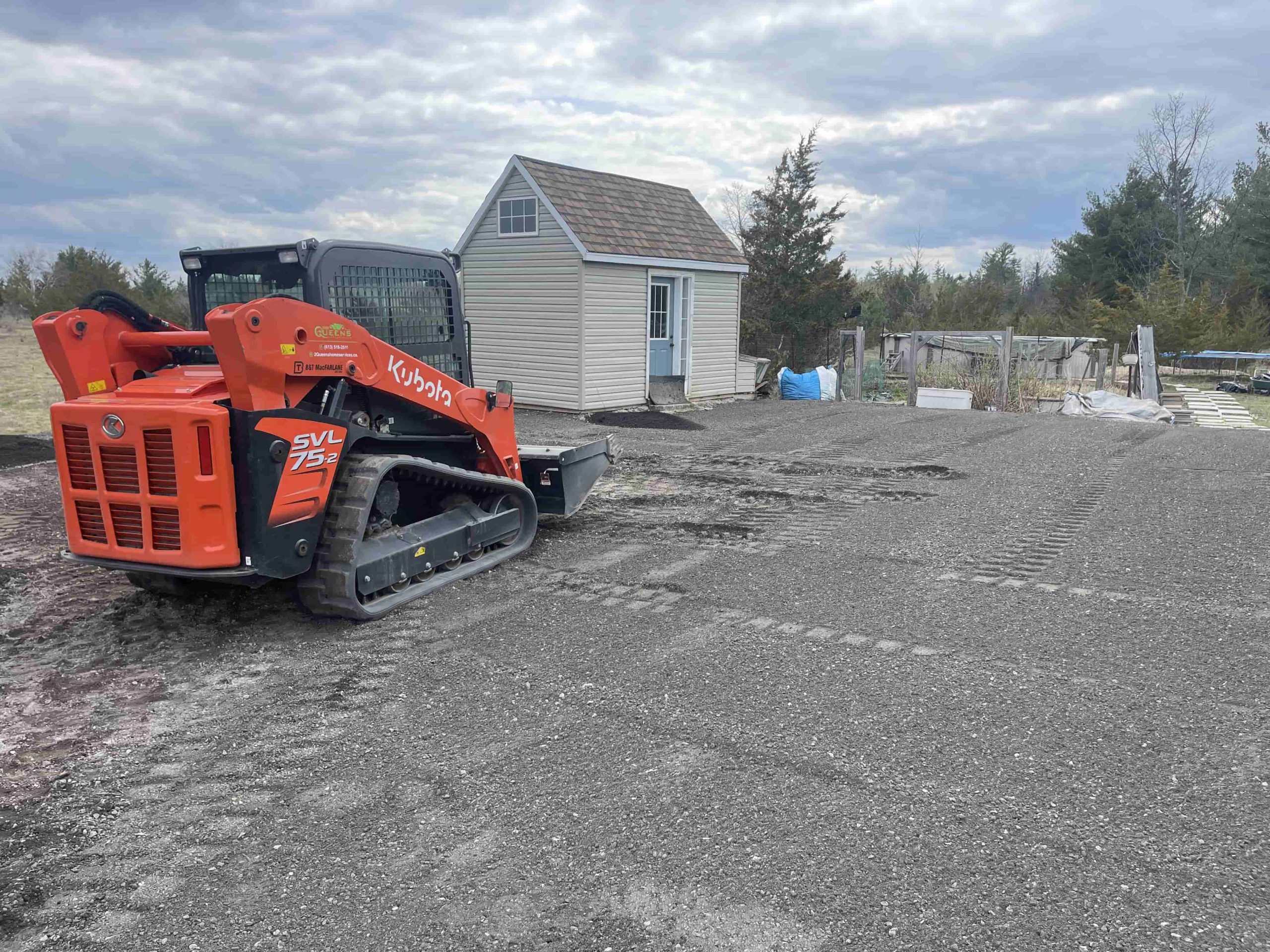 A Kubota track loader is stationed on a recently levelled piece of land, indicating ongoing land preparation.