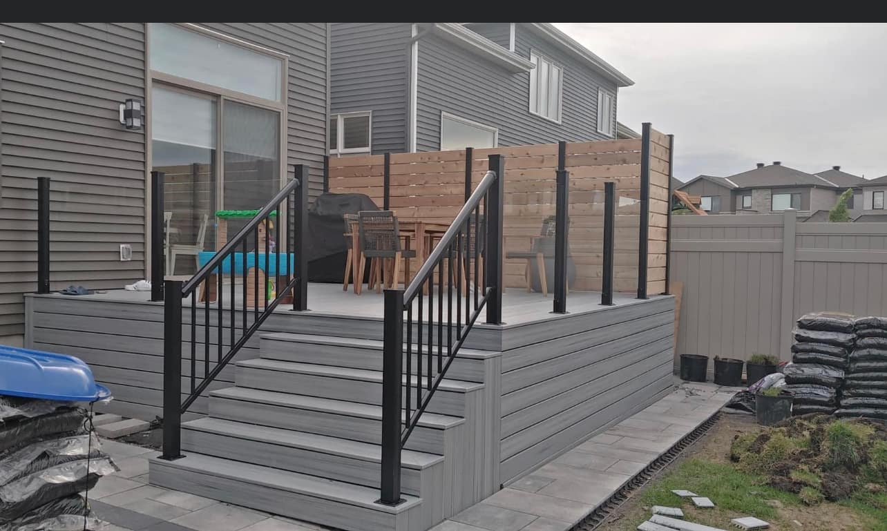 An expansive backyard deck featuring with modern railings offers a cozy outdoor living space
