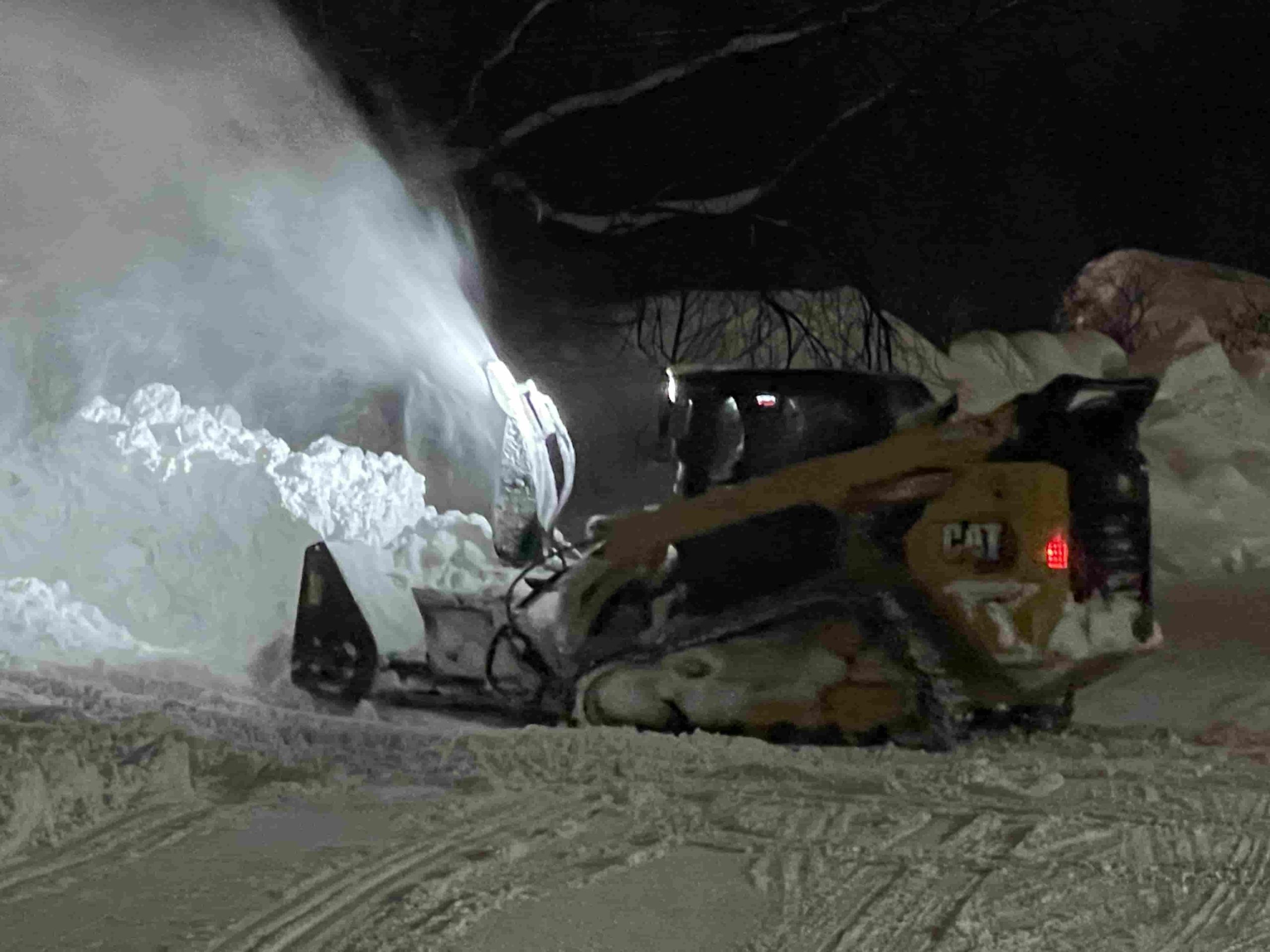 A powerful CAT skid steer loader is at work for snow removal.