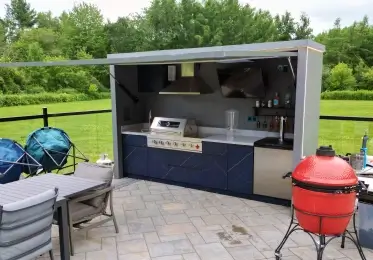 two queens home services outdoor kitchen featuring a grill and a dining table